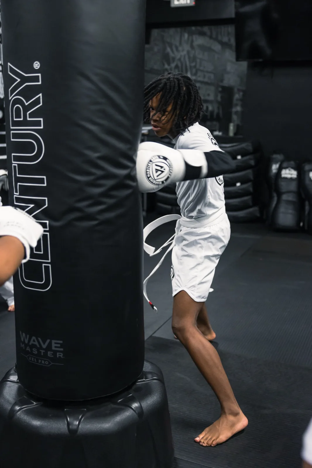 A Warrior kid driving a punch into the bag — energy with a job to do